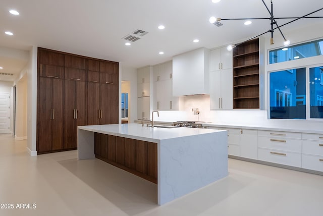 kitchen with visible vents, modern cabinets, open shelves, a sink, and white cabinets