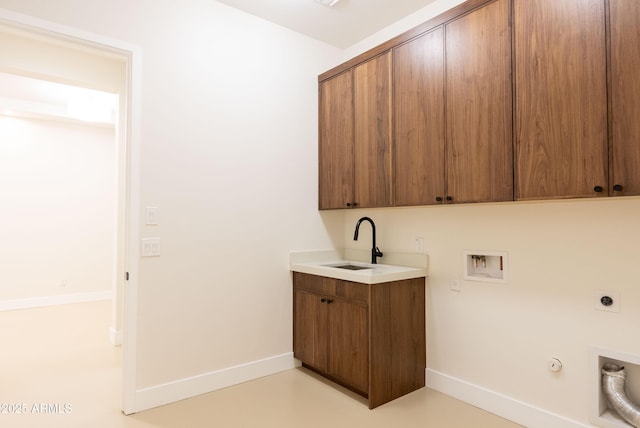 washroom featuring cabinet space, a sink, gas dryer hookup, electric dryer hookup, and baseboards