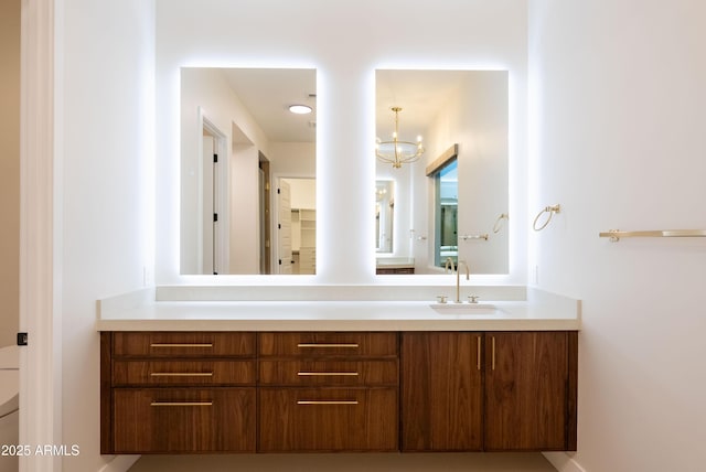 bathroom featuring a notable chandelier and vanity