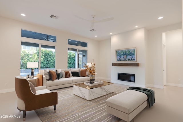living area with a glass covered fireplace, a ceiling fan, recessed lighting, and visible vents
