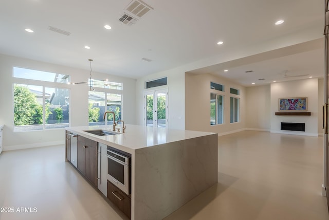 kitchen with recessed lighting, baseboards, visible vents, and a sink