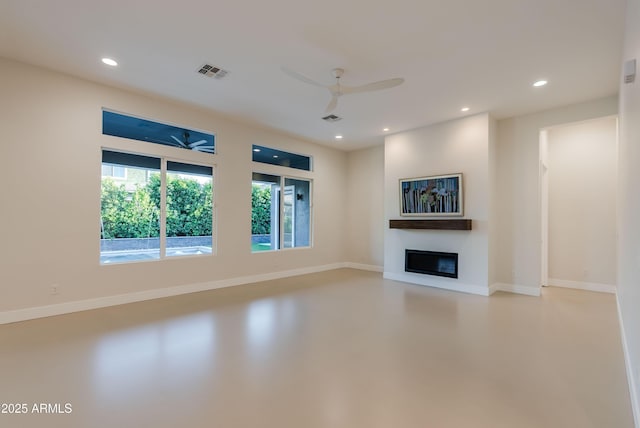 unfurnished living room with a glass covered fireplace, finished concrete flooring, a ceiling fan, and visible vents