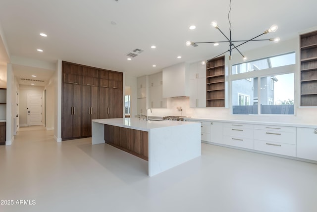 kitchen with open shelves, modern cabinets, light countertops, white cabinetry, and a sink
