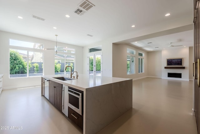 kitchen with french doors, visible vents, a sink, concrete floors, and recessed lighting