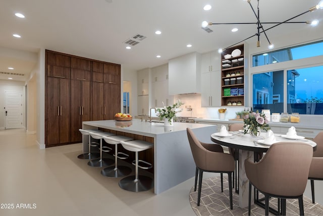 kitchen with modern cabinets, open shelves, concrete flooring, light countertops, and white cabinets
