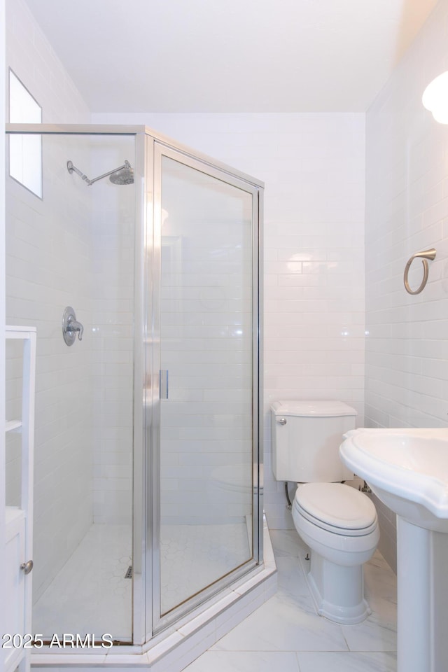 1006 S Una Ave, Tempe, AZ 85281 - bathroom with a stall shower, tile walls, and marble look tile flooring