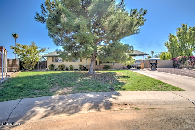 view of property hidden behind natural elements featuring a front lawn