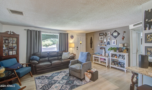 living room featuring a textured ceiling and light wood-type flooring