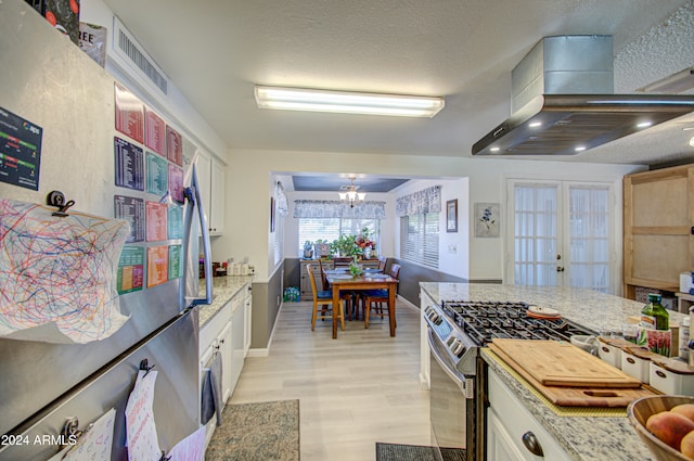 kitchen featuring light stone counters, extractor fan, white cabinetry, light hardwood / wood-style floors, and stainless steel appliances