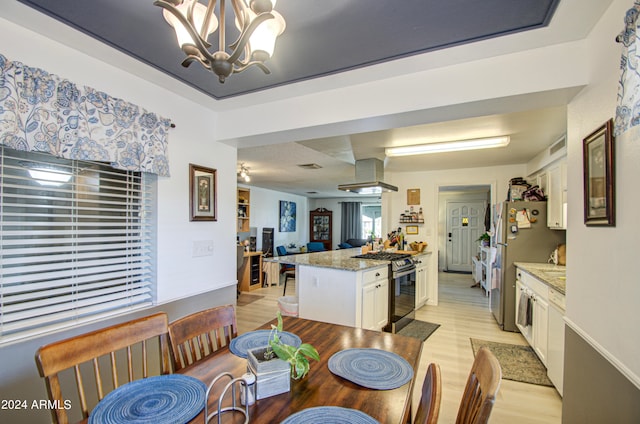 dining area with an inviting chandelier and light hardwood / wood-style floors