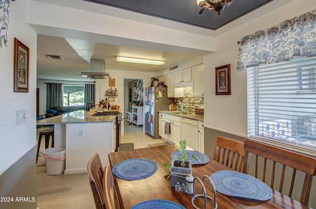 dining space with sink and light wood-type flooring