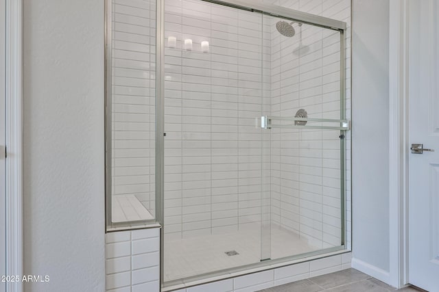 full bath with a textured wall and a shower stall