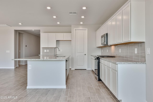 kitchen featuring a sink, appliances with stainless steel finishes, backsplash, and recessed lighting