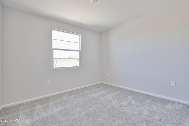 spare room featuring carpet floors and baseboards