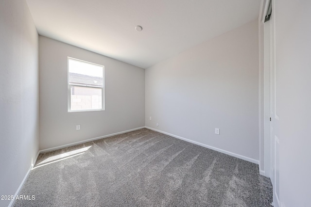 carpeted spare room featuring baseboards