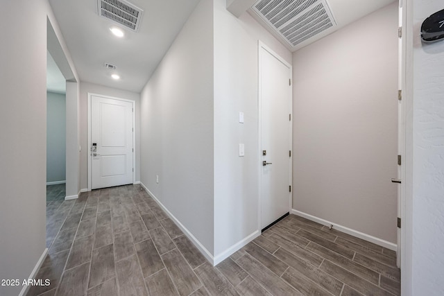 hallway with wood tiled floor, baseboards, and visible vents