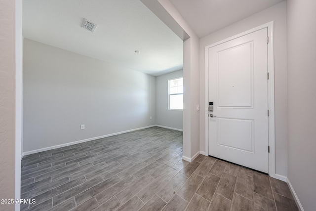 entrance foyer with baseboards, visible vents, and wood finished floors