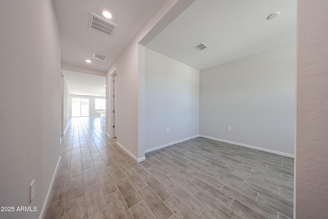 corridor featuring light wood finished floors and visible vents