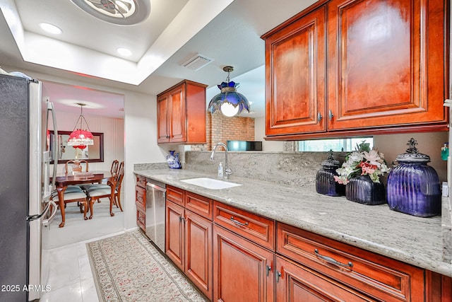 5349 W Acapulco Ln, Glendale, AZ 85306 - kitchen with stainless steel appliances, brown cabinetry, light stone counters, recessed lighting, and a tray ceiling