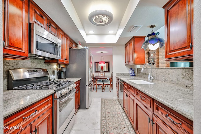 5349 W Acapulco Ln, Glendale, AZ 85306 - kitchen featuring stainless steel appliances, backsplash, a raised ceiling, light stone countertops, and pendant lighting