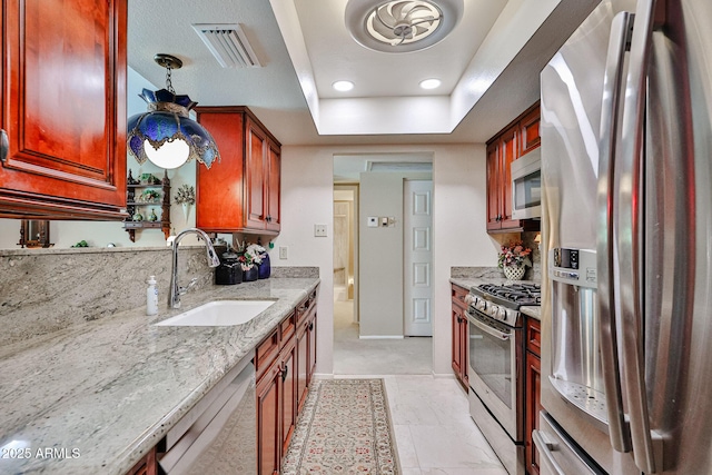 5349 W Acapulco Ln, Glendale, AZ 85306 - kitchen featuring stainless steel appliances, light stone countertops, a raised ceiling, dark brown cabinets, and recessed lighting