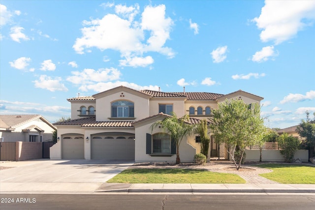 mediterranean / spanish house featuring a garage and a front lawn