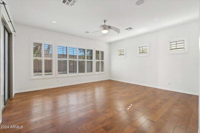 unfurnished room featuring dark wood-type flooring and ceiling fan