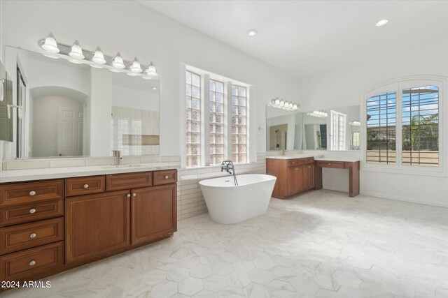 bathroom with plenty of natural light, a bath, and vanity