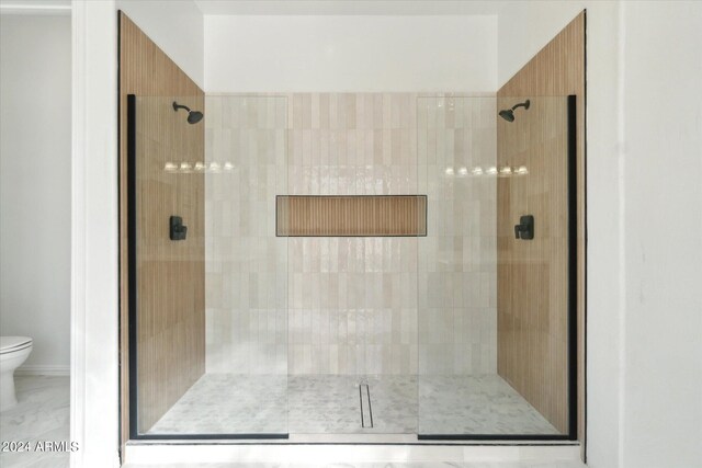 bathroom with toilet and a shower with shower door