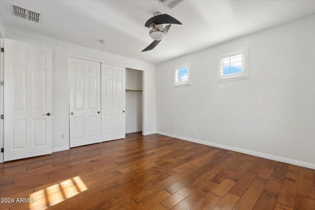 unfurnished bedroom featuring dark hardwood / wood-style flooring, a closet, and ceiling fan