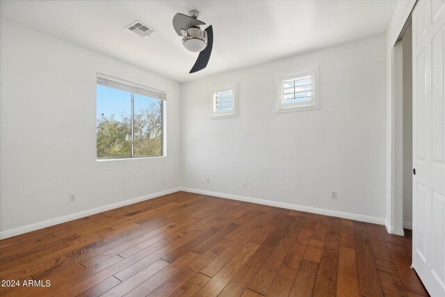 unfurnished bedroom with dark hardwood / wood-style flooring, a closet, and ceiling fan