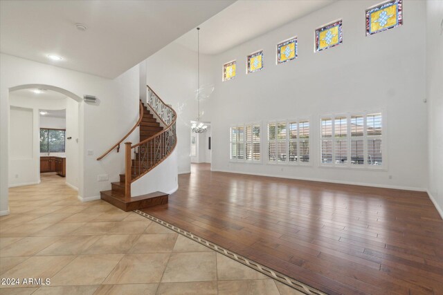 entrance foyer featuring a wealth of natural light, light hardwood / wood-style flooring, a chandelier, and a towering ceiling