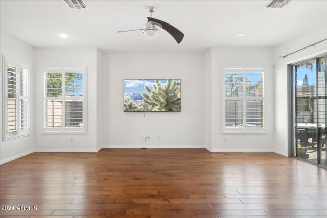 unfurnished room with ceiling fan and dark hardwood / wood-style flooring