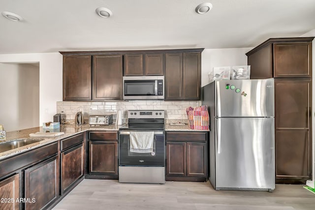 25787 W Allen St, Buckeye, AZ 85326 - kitchen with stainless steel appliances, dark brown cabinets, and light stone countertops