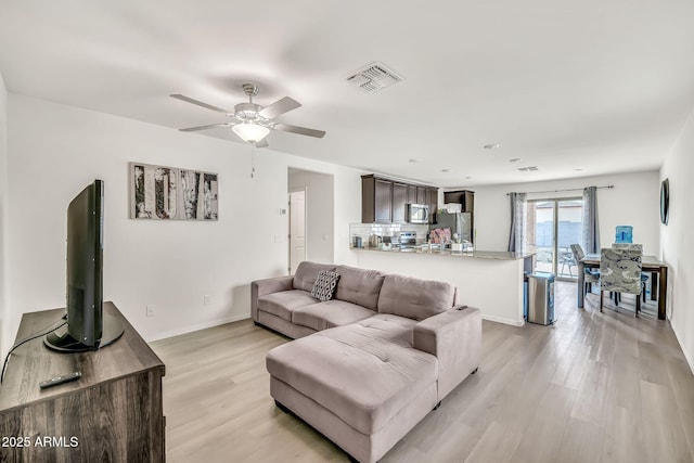 25787 W Allen St, Buckeye, AZ 85326 - living room with light wood-type flooring, a ceiling fan, and baseboards