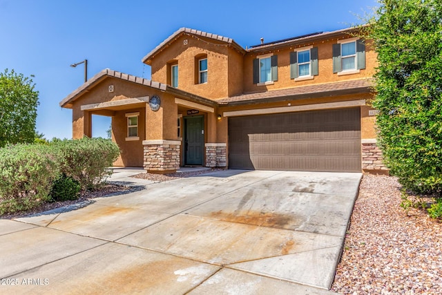 12128 W Range Mule Dr, Peoria, AZ 85383 - view of front of property featuring stone siding, an attached garage, driveway, and stucco siding
