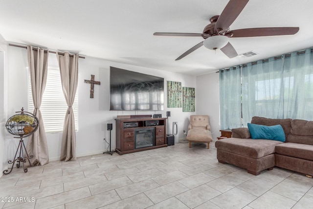 12128 W Range Mule Dr, Peoria, AZ 85383 - living room with ceiling fan, healthy amount of natural light, light tile patterned flooring, and a glass covered fireplace