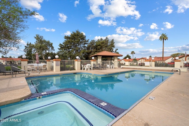 community pool featuring a patio, a community hot tub, and fence