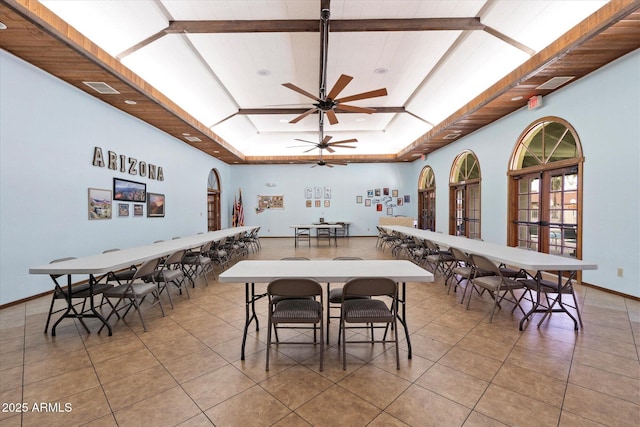 dining room featuring visible vents, baseboards, a tray ceiling, light tile patterned flooring, and a ceiling fan