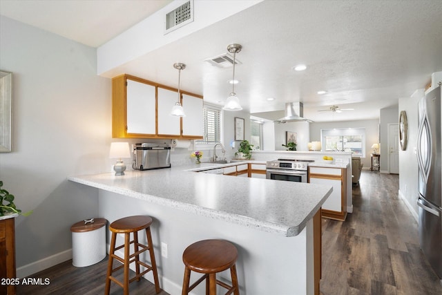 kitchen featuring a sink, visible vents, a peninsula, and appliances with stainless steel finishes