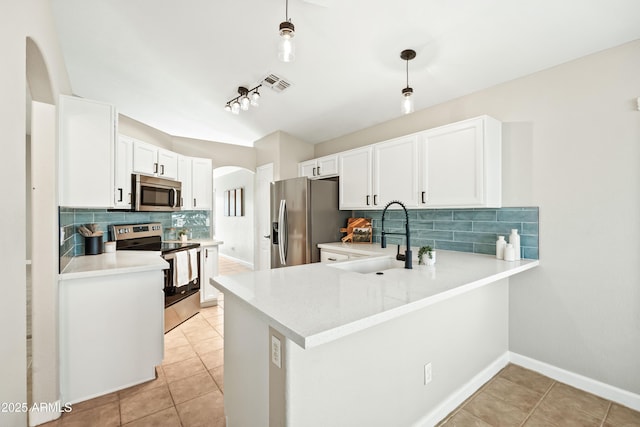 16424 S 46th Way, Phoenix, AZ 85048 - kitchen featuring appliances with stainless steel finishes, a sink, arched walkways, decorative backsplash, and white cabinetry