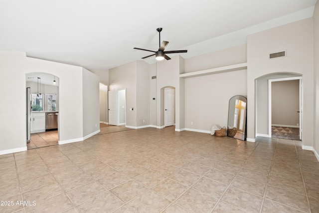 16424 S 46th Way, Phoenix, AZ 85048 - unfurnished living room featuring arched walkways, ceiling fan, light tile patterned flooring, a high ceiling, and baseboards