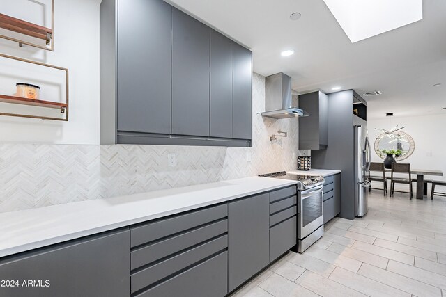 2942 N 81st Pl, Scottsdale, AZ 85251 - kitchen featuring decorative backsplash, stainless steel appliances, gray cabinets, and wall chimney range hood