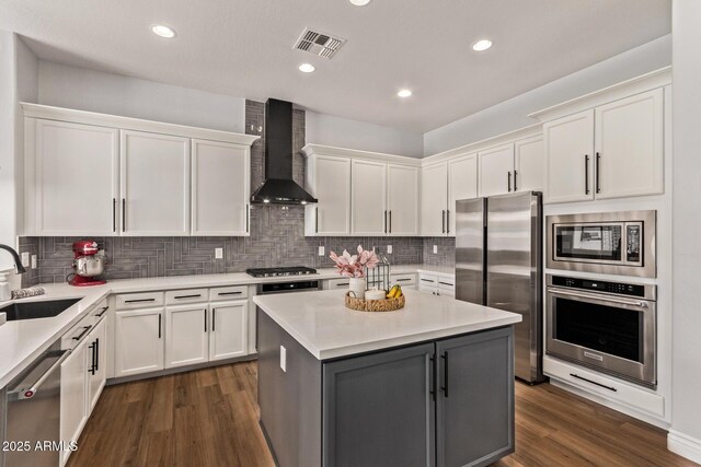 4667 E Reins Rd, Gilbert, AZ 85297 - kitchen featuring appliances with stainless steel finishes, wall chimney exhaust hood, a sink, light countertops, and dark wood-style flooring