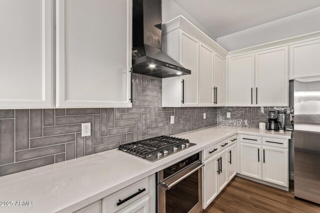 4667 E Reins Rd, Gilbert, AZ 85297 - kitchen featuring wall chimney range hood, stainless steel appliances, tasteful backsplash, and white cabinetry