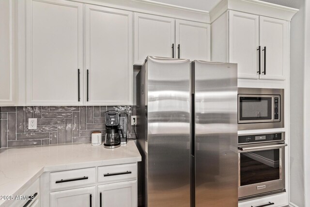 4667 E Reins Rd, Gilbert, AZ 85297 - kitchen with stainless steel appliances, white cabinetry, and backsplash