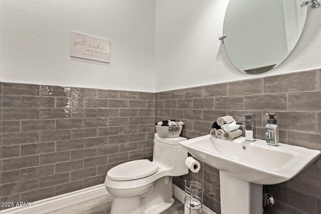 4667 E Reins Rd, Gilbert, AZ 85297 - bathroom featuring toilet, tile walls, and a sink