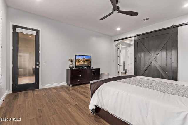 4667 E Reins Rd, Gilbert, AZ 85297 - bedroom featuring a barn door, wood finished floors, baseboards, and recessed lighting