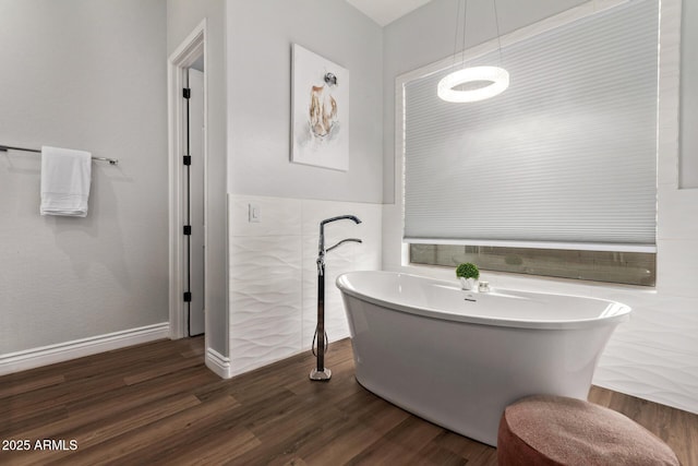 4667 E Reins Rd, Gilbert, AZ 85297 - bathroom with a freestanding tub, wood finished floors, and tile walls