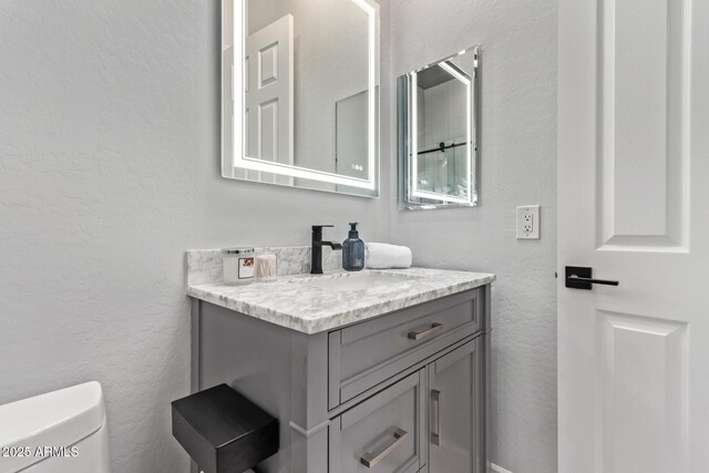 4667 E Reins Rd, Gilbert, AZ 85297 - bathroom with a textured wall, vanity, and toilet